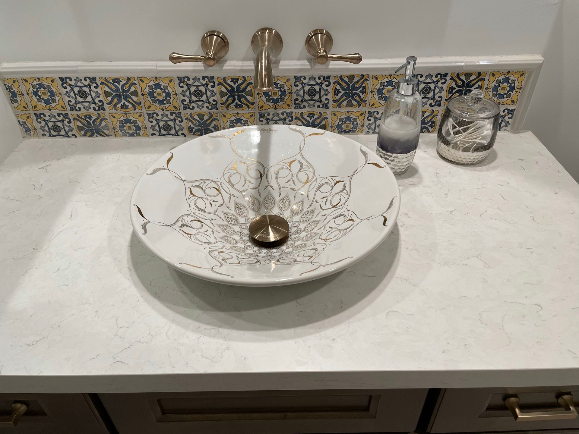 A bathroom sink with a faucet and a soap dispenser on the counter.