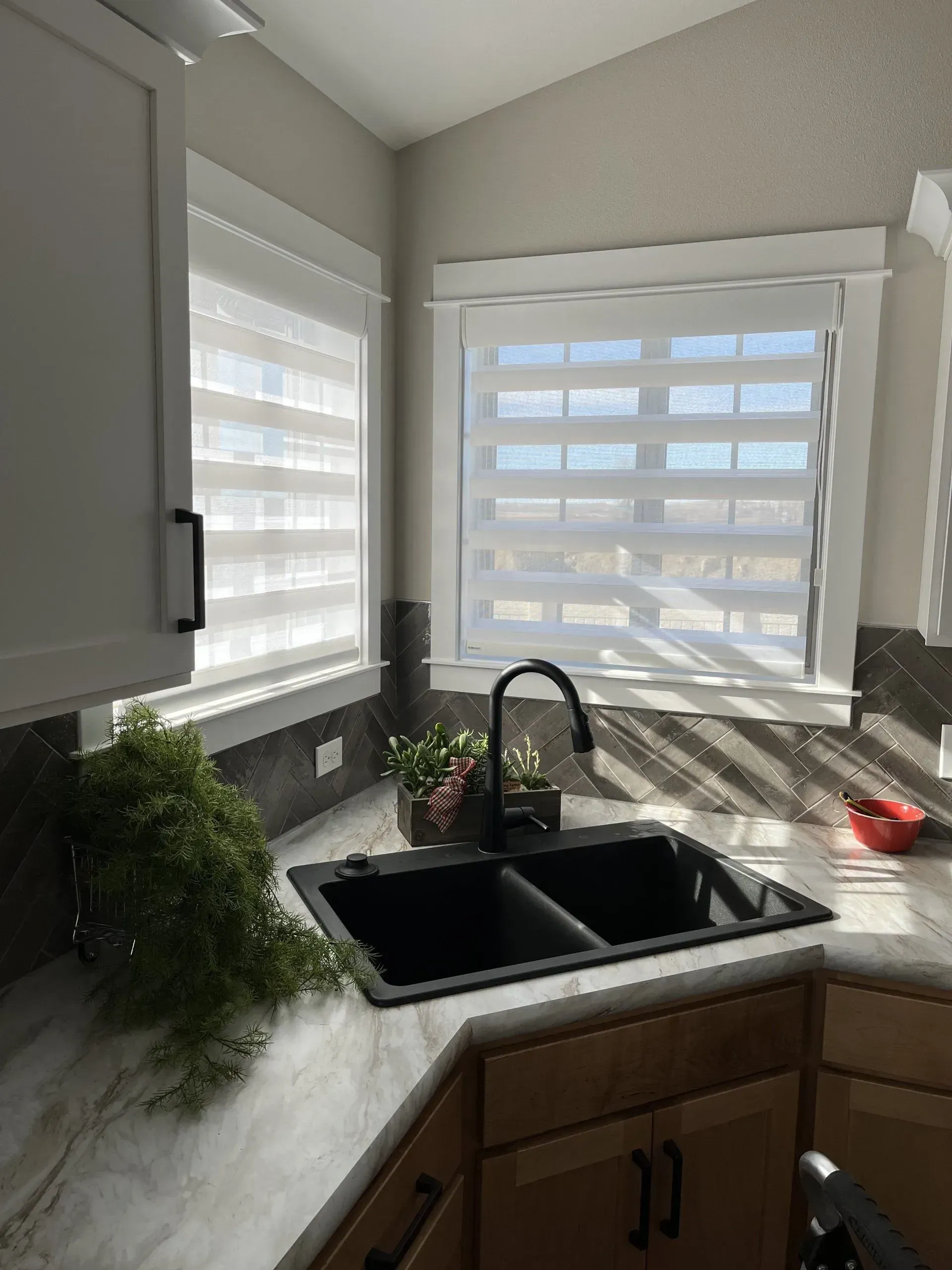 A kitchen with a sink and a window with blinds.