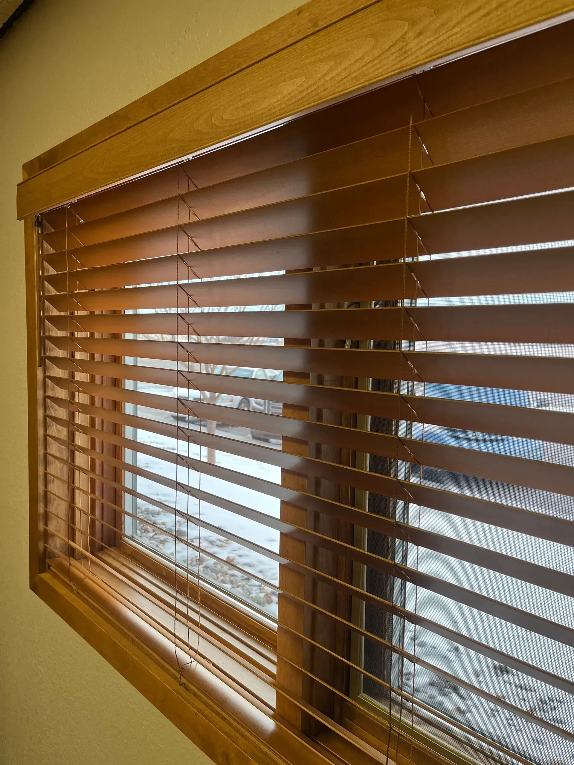 A close up of a window with wooden blinds on it