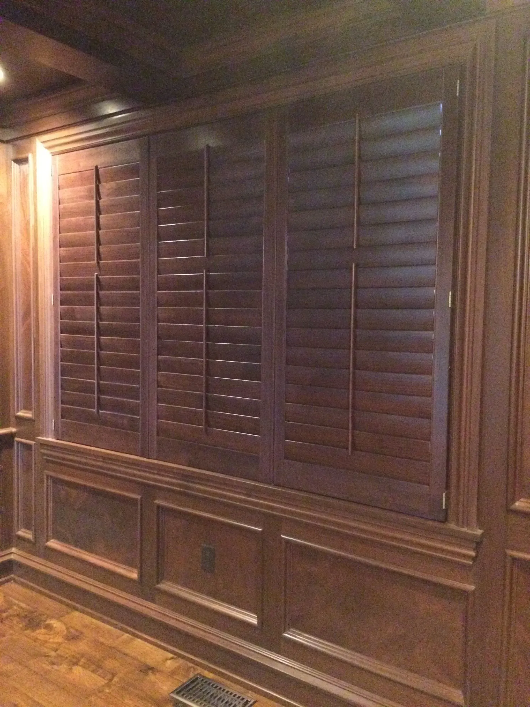 A wall with a lot of wooden shutters on it