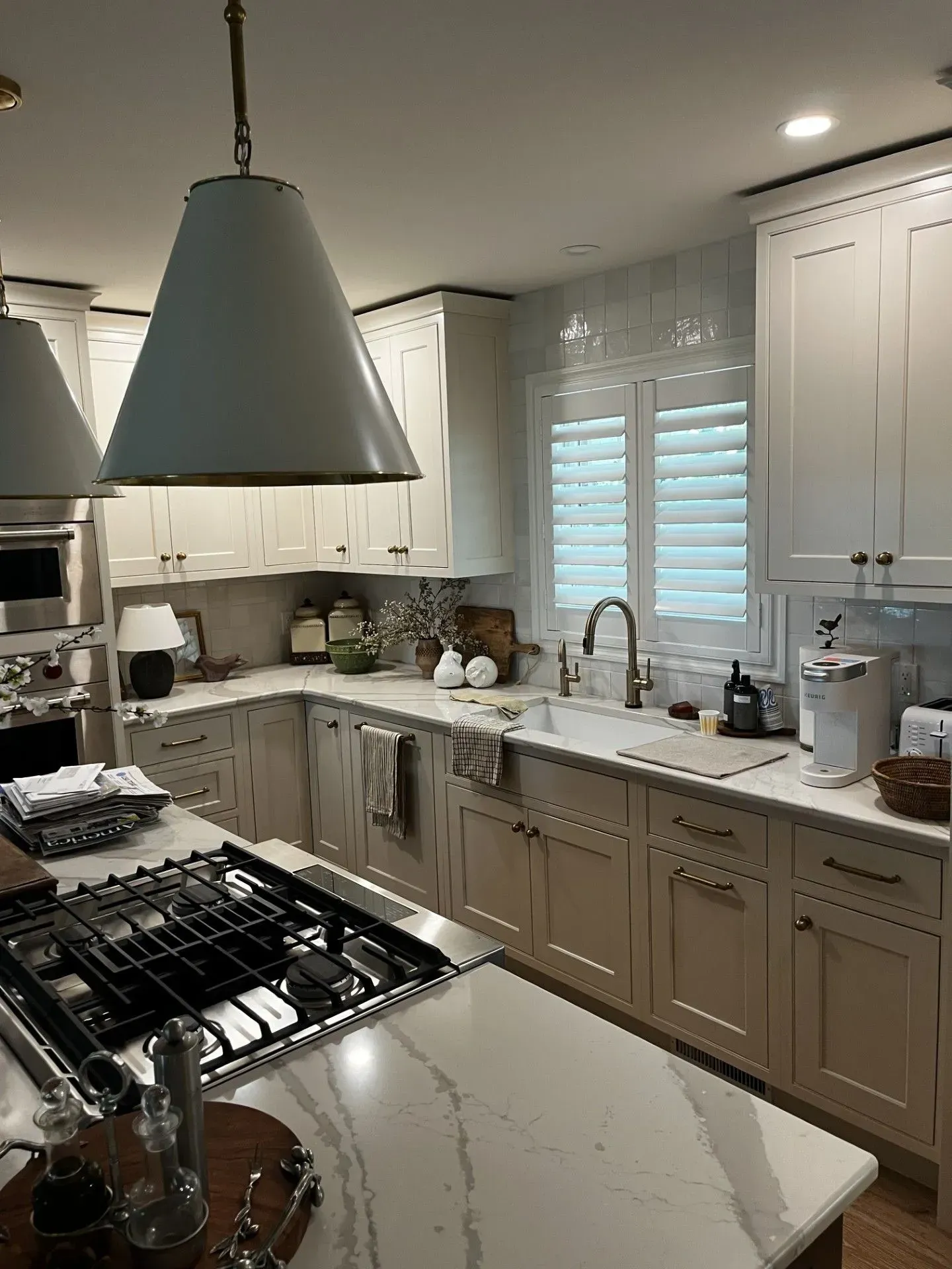 A kitchen with white cabinets, a stove, a sink, and a large island.