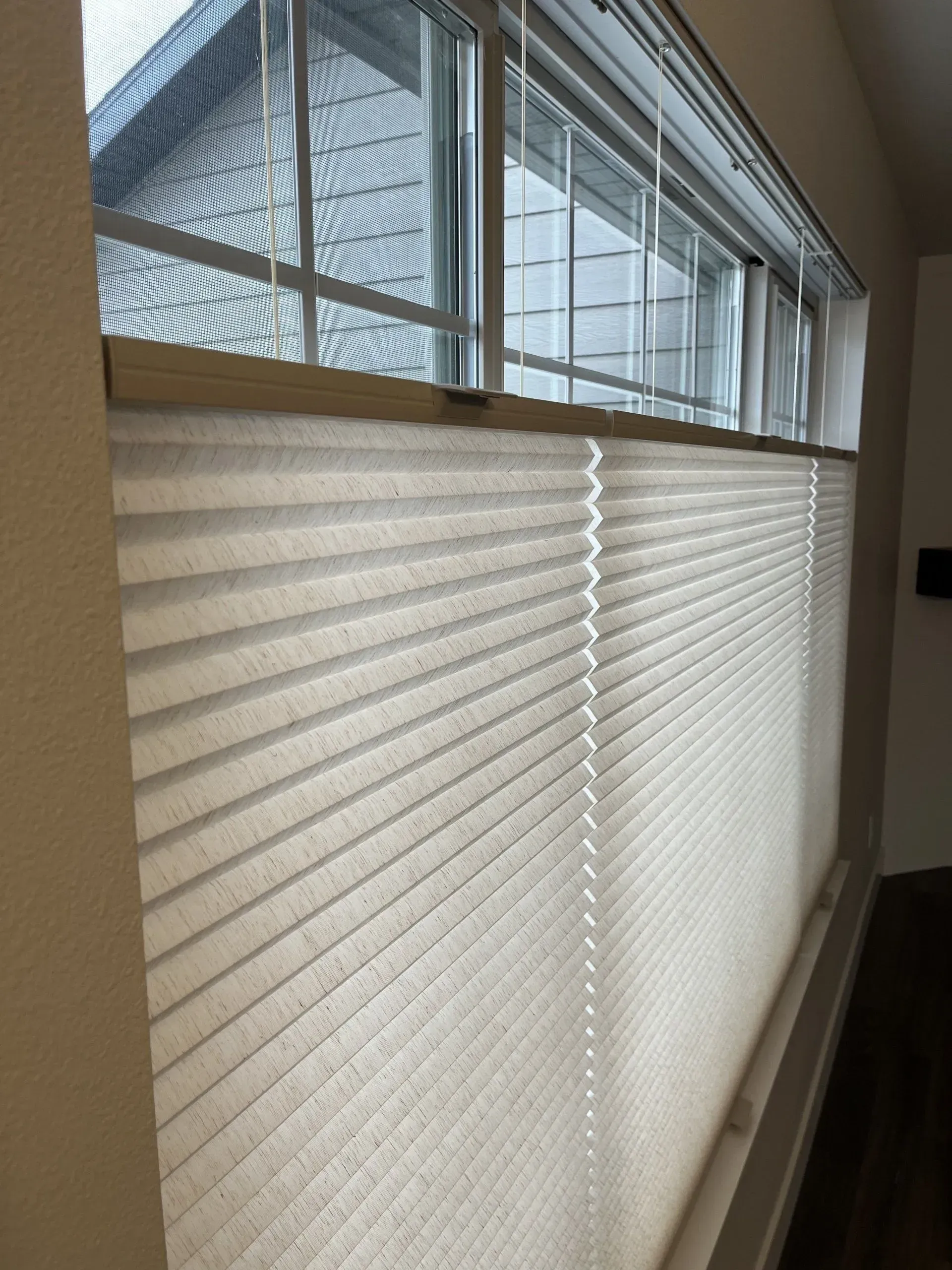 A window with blinds on it in a living room.