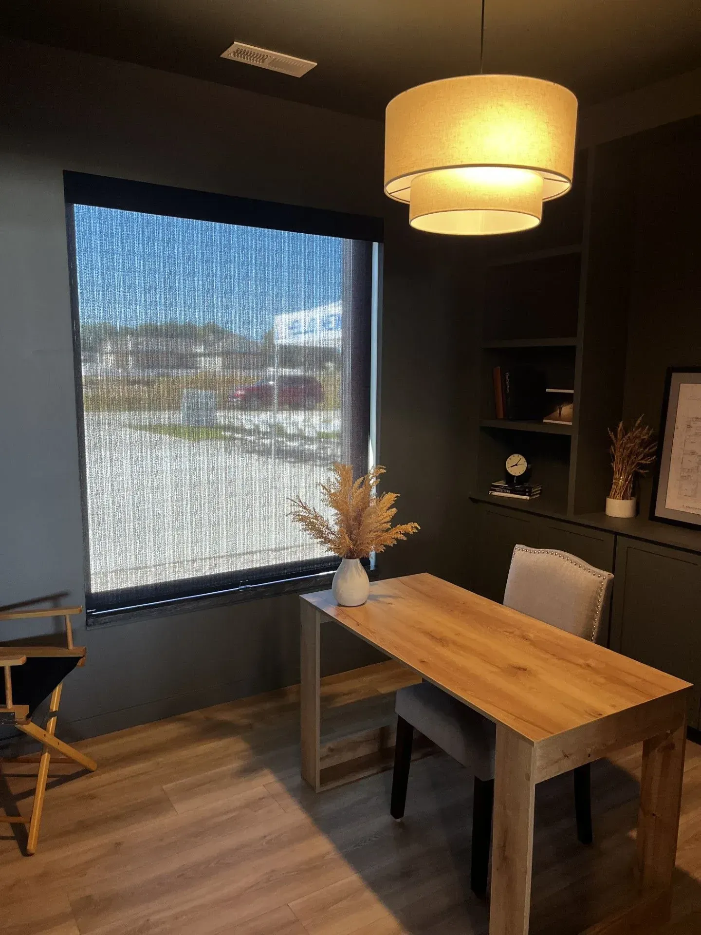 A room with a table and chairs in front of a window.