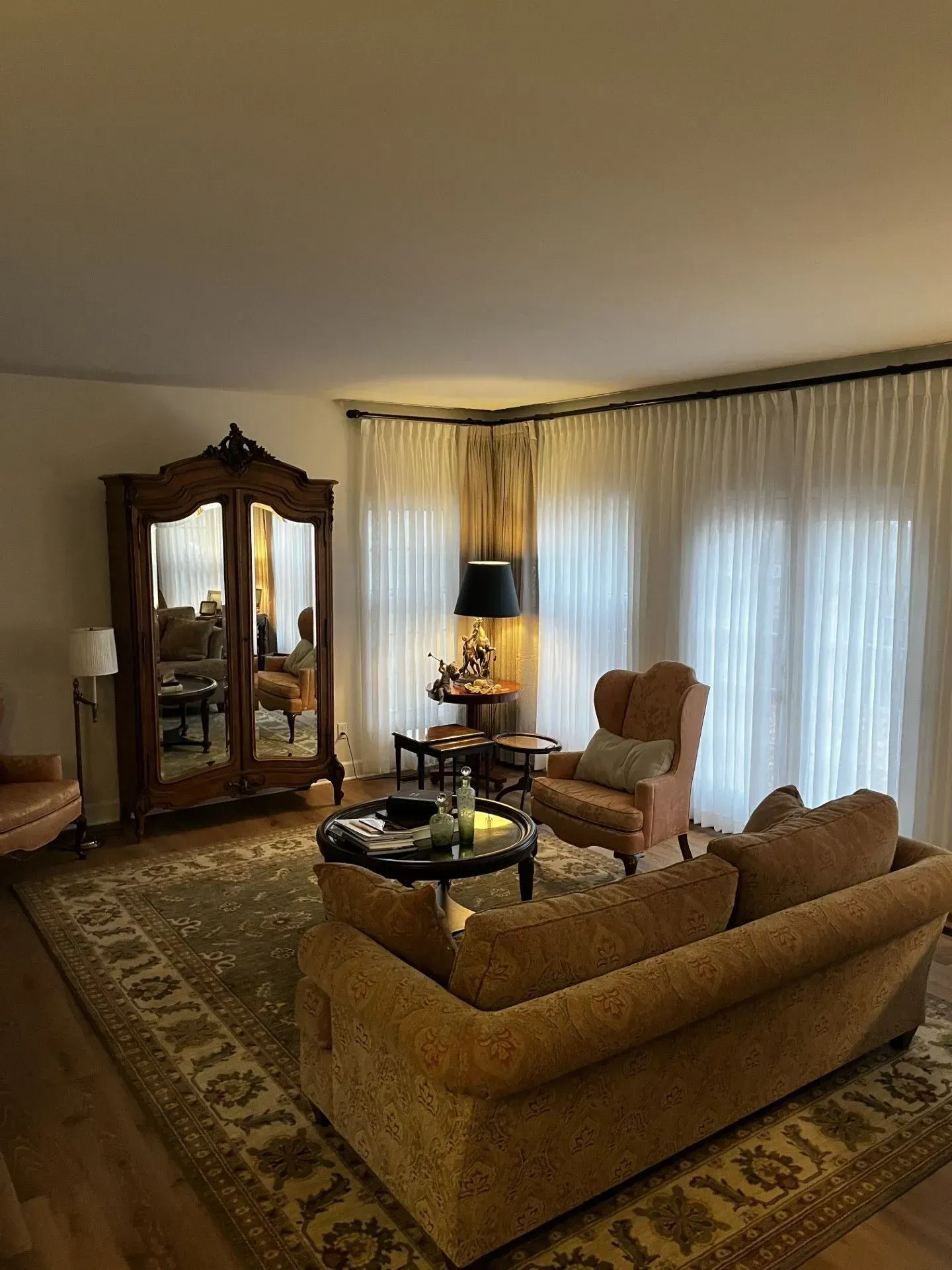 A living room with a couch, chairs, and a rug.