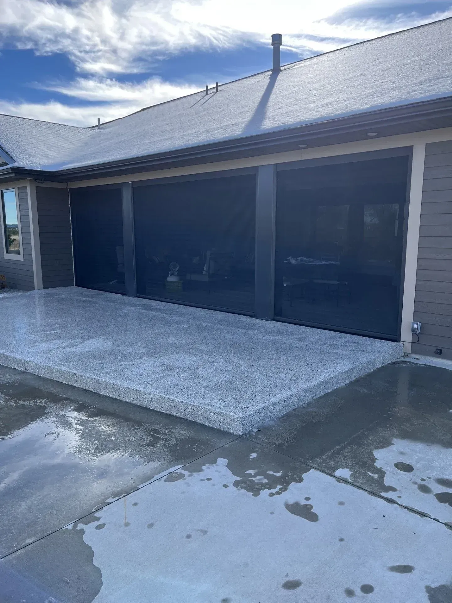 A house with a garage and a patio in front of it.