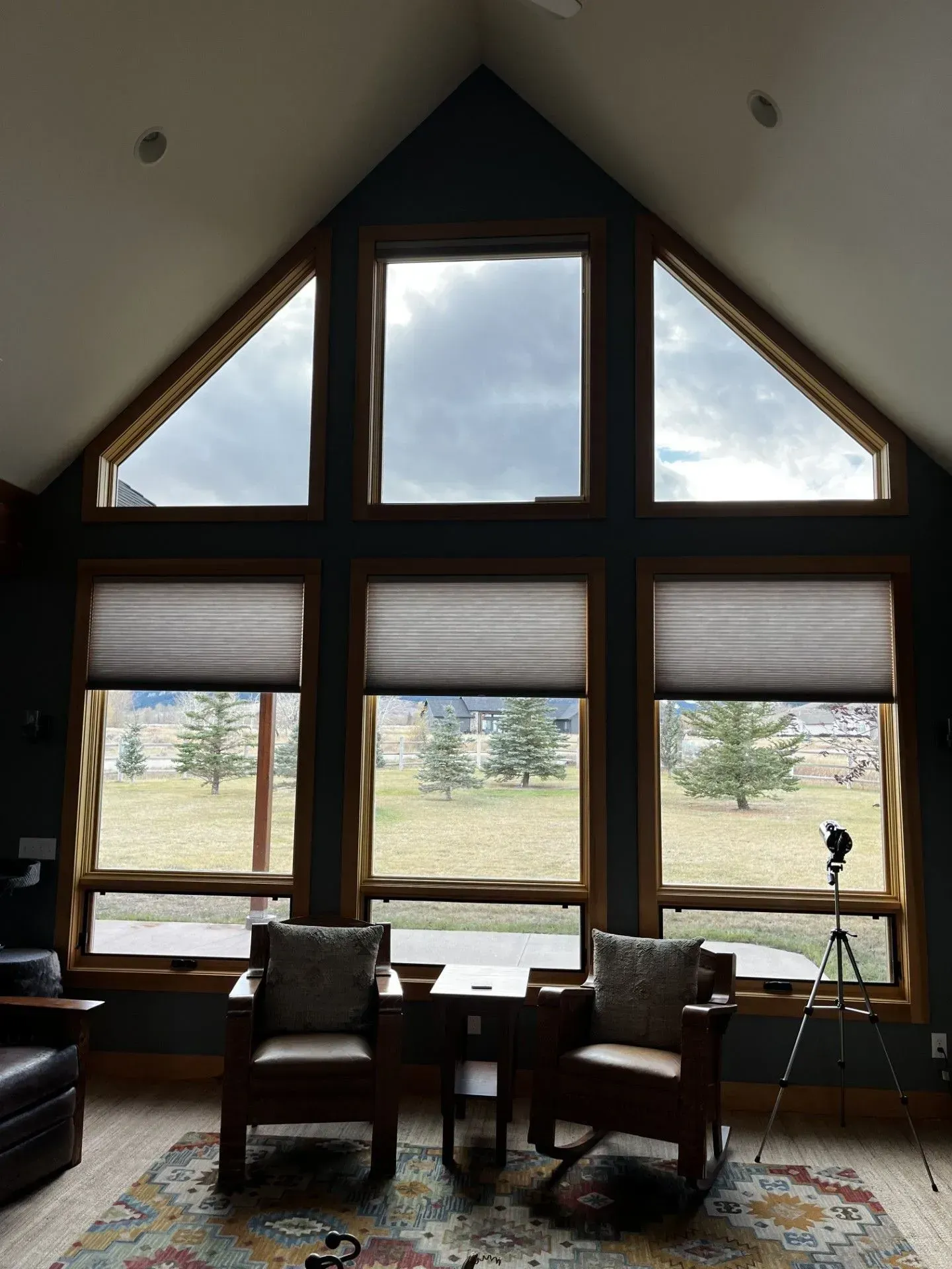 A living room with a lot of windows and chairs