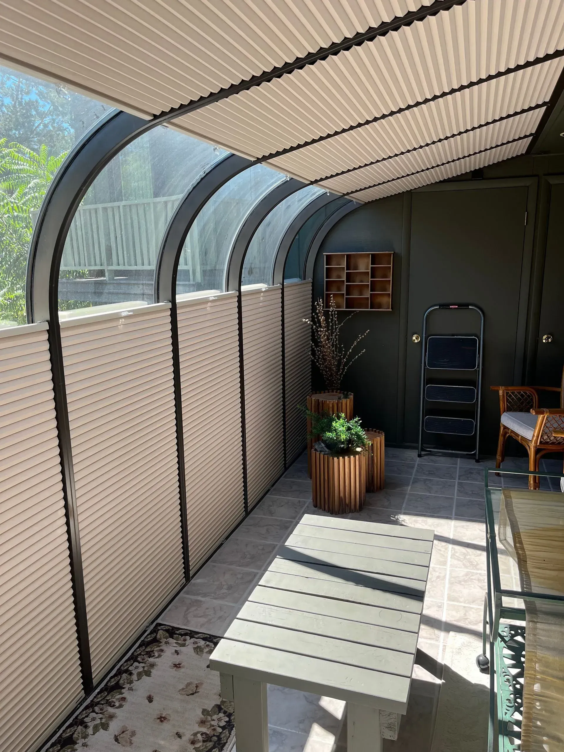 A sunroom with a table and chairs and a ladder.