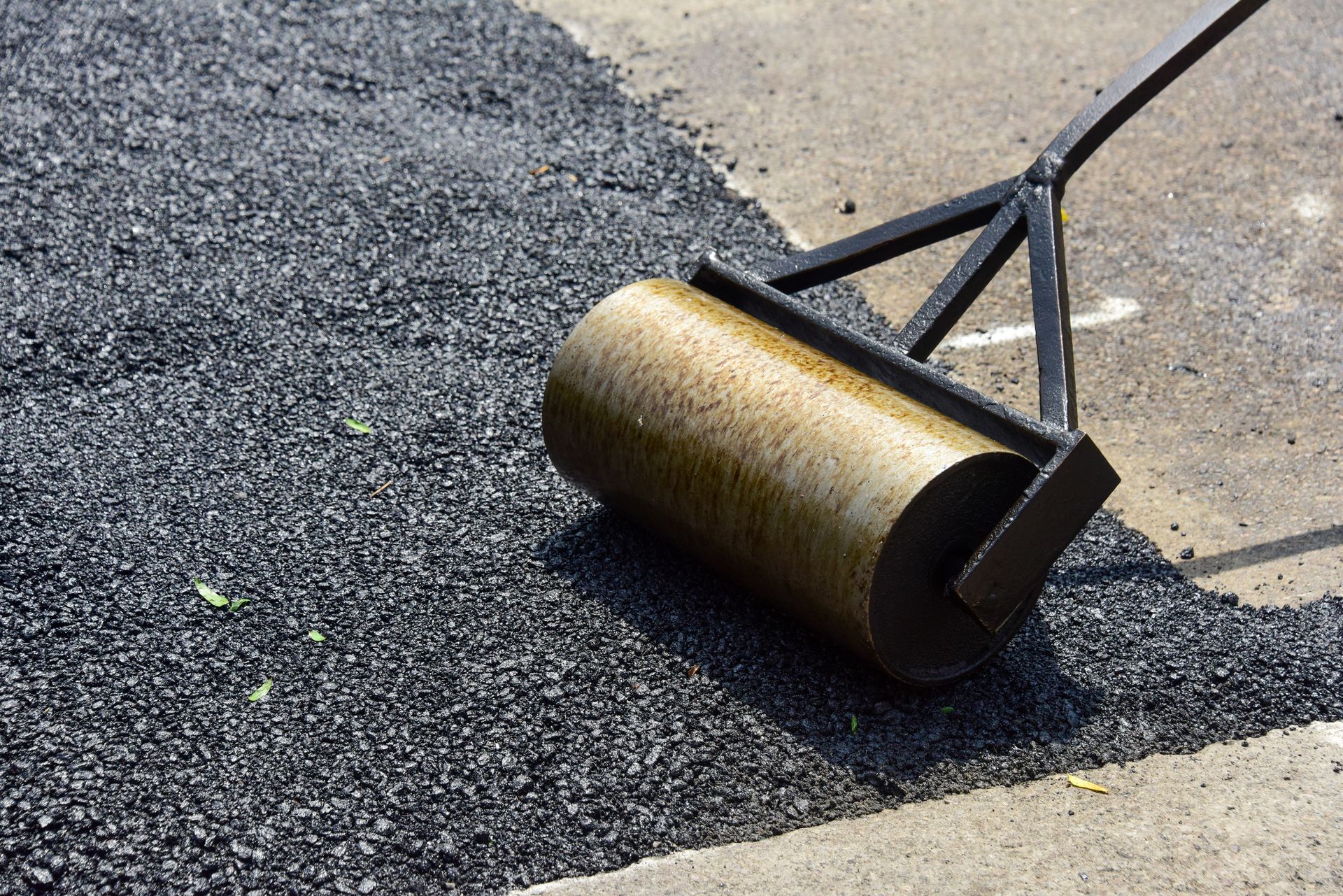 A roller is sitting on top of a pile of asphalt.