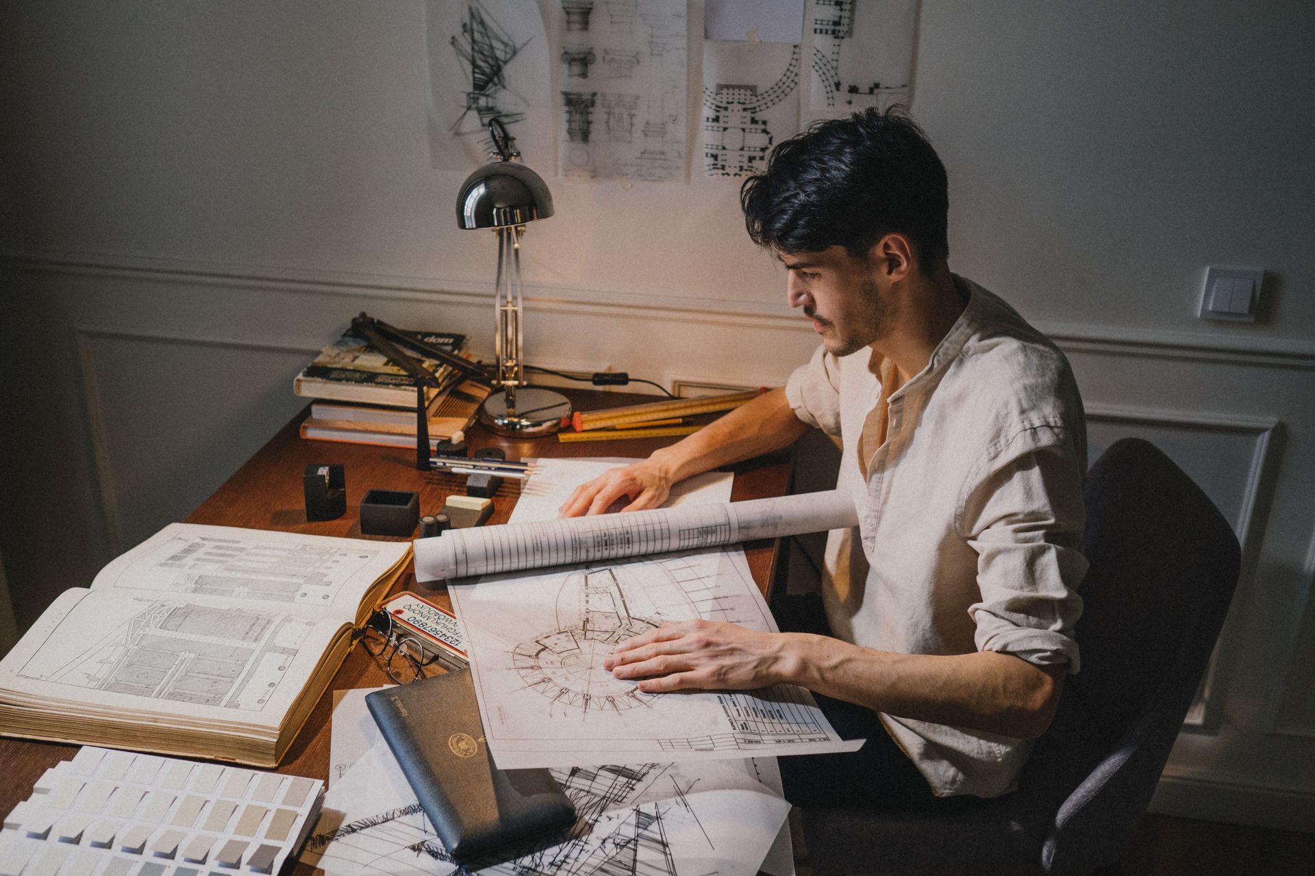 Tecnico durante la verifica di planimetrie per lavori con pareti in cartongesso e modifica della distribuzione interna.