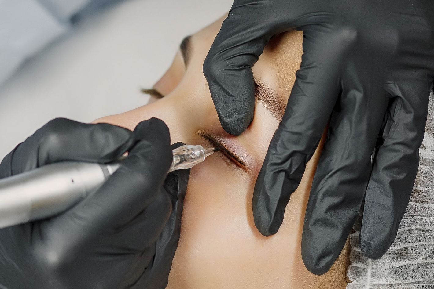 Eine Person, die sich einer Permanent-Make-up-Behandlung unterzieht. 