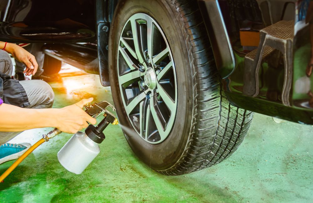 Person Spraying a Car Tire With a Cleaning Solution — SPW Engineering & Powdercoating In Ballarat, VIC