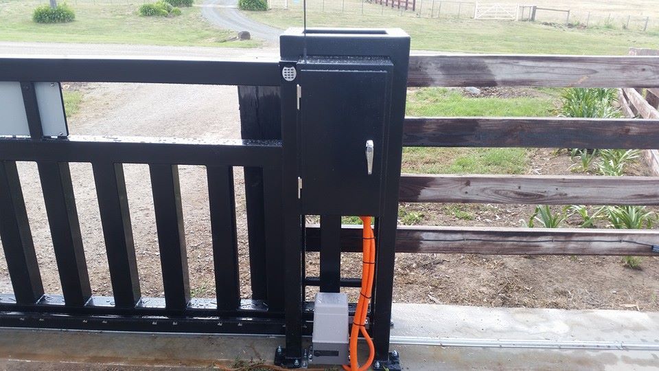 Black Electric Gate Control Box on a Fence With an Orange Cable — SPW Engineering & Powdercoating In Ballarat, VIC