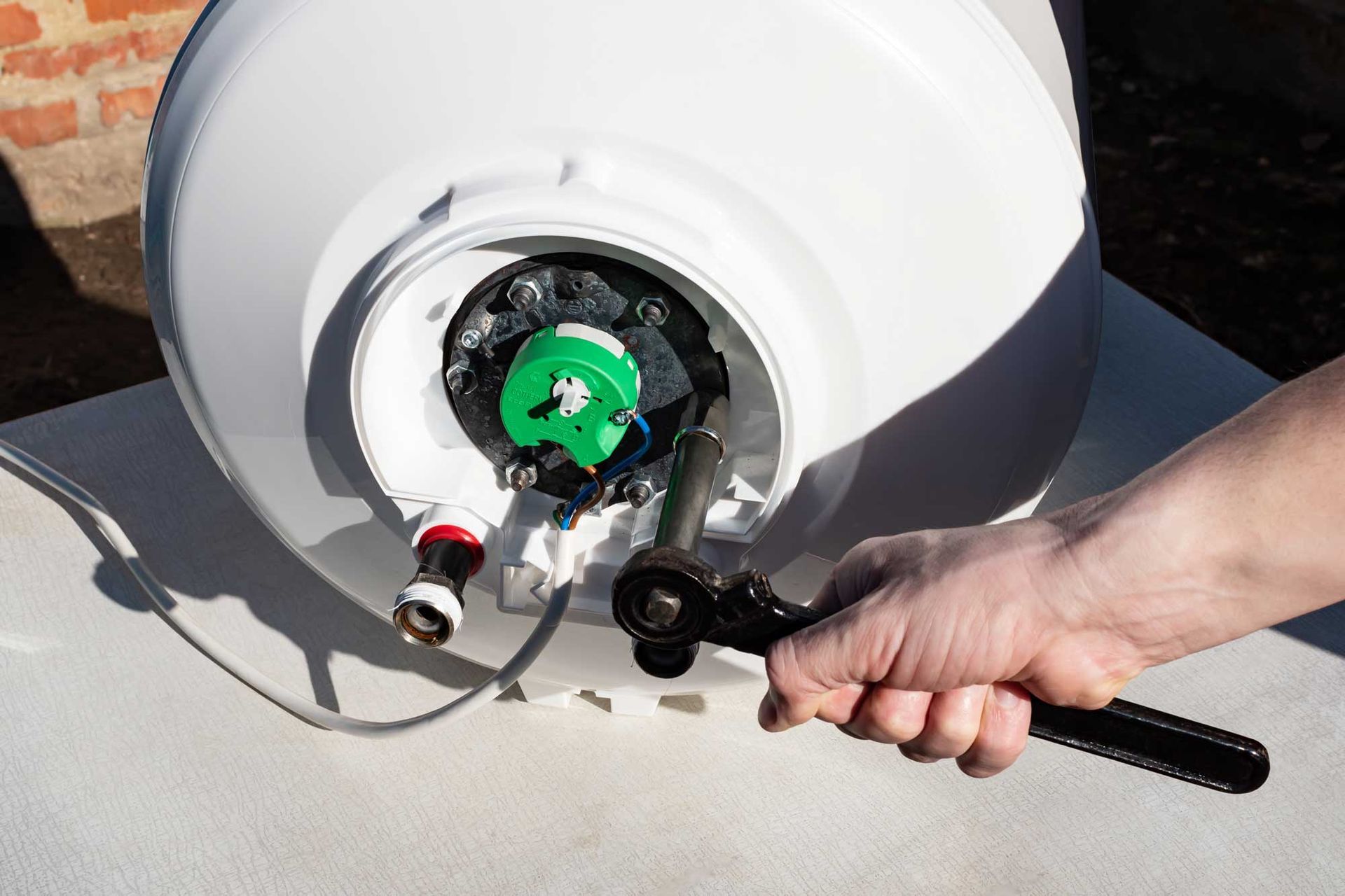 Hand tightening a gas cylinder valve with a wrench and hose attached Hand tightening a gas cylinder valve with a wrench and hose attached