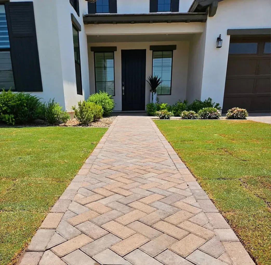 A brick walkway leading to the front door of a house.