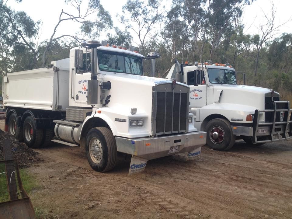 A Bulldozer is Driving Down a Dirt Road in the Woods — Eddy’s Excavations & Bobcat Hire In Biloela, QLD