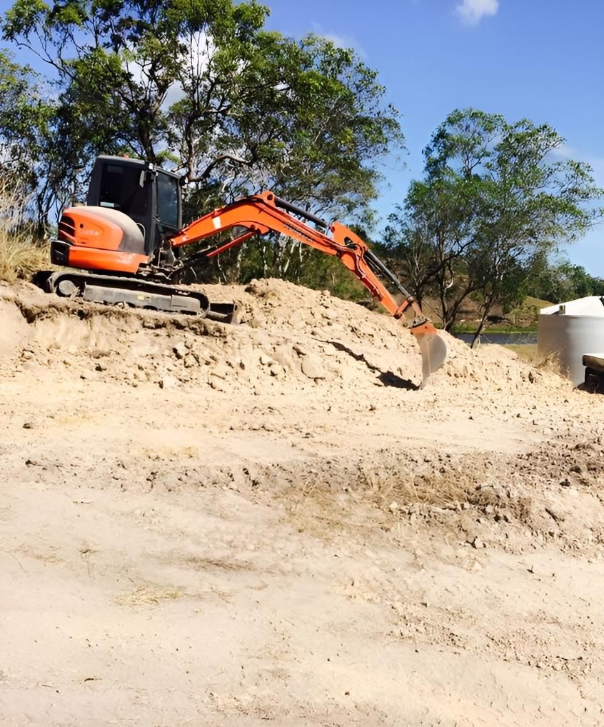A Yellow Excavator is Demolishing a Building in a Construction Site — Eddy’s Excavations & Bobcat Hire In Boyne Valley, QLD
