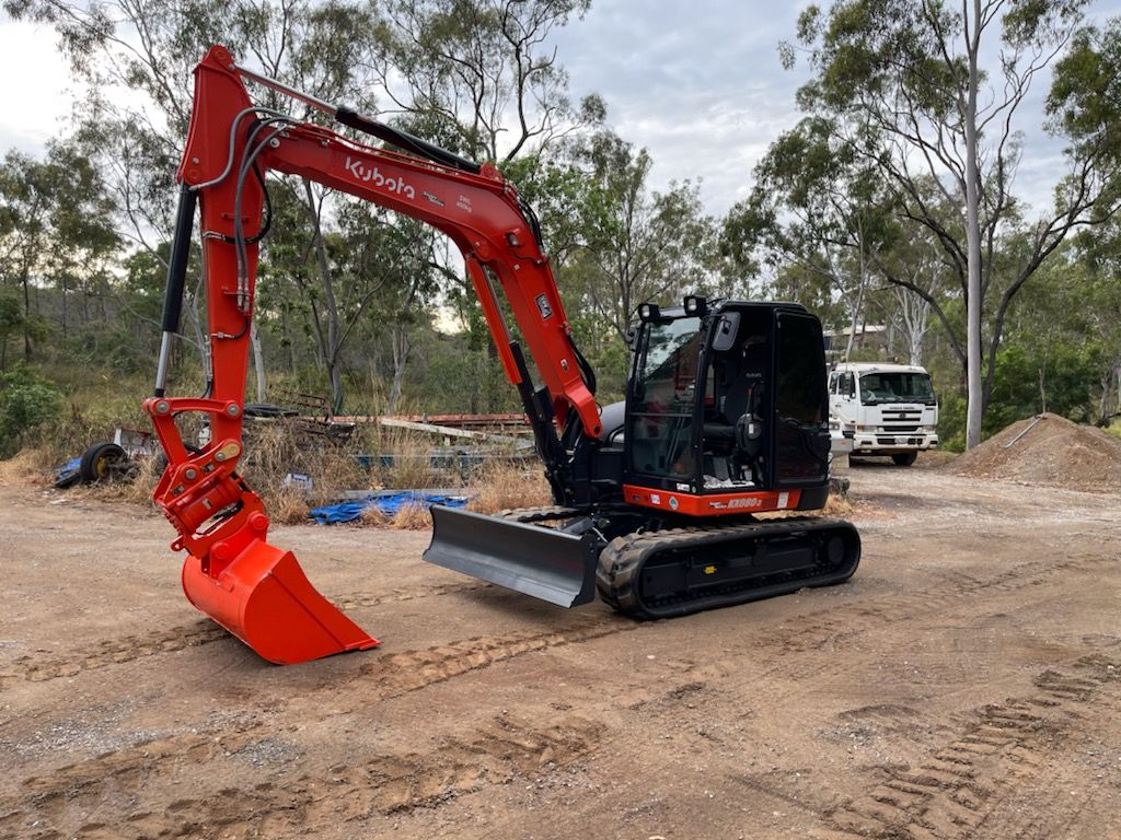 A Yellow Excavator is Digging a Hole in a Dirt Field — Eddy’s Excavations & Bobcat Hire In Wurdong Heights, QLD
