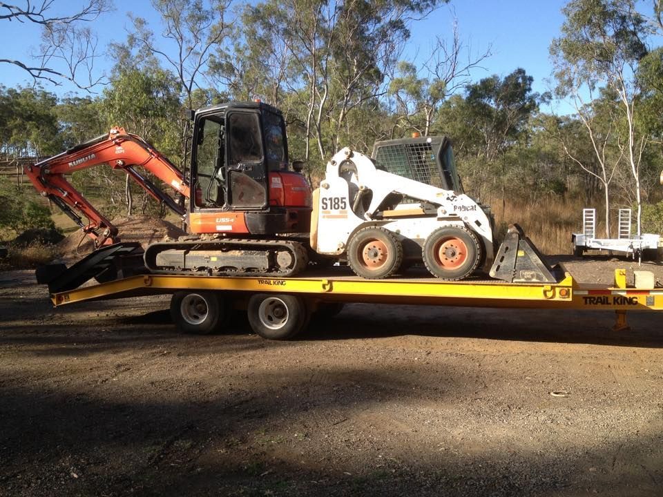 A Yellow Bulldozer is Sitting on Top of a Dirt Field — Eddy’s Excavations & Bobcat Hire In Tannum Sands, QLD