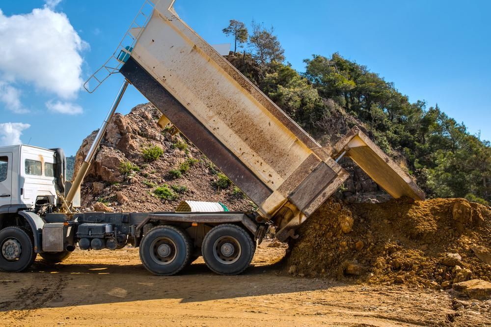 A Dump Truck is Dumping Dirt on a Construction Site — Eddy’s Excavations & Bobcat Hire In Biloela, QLD