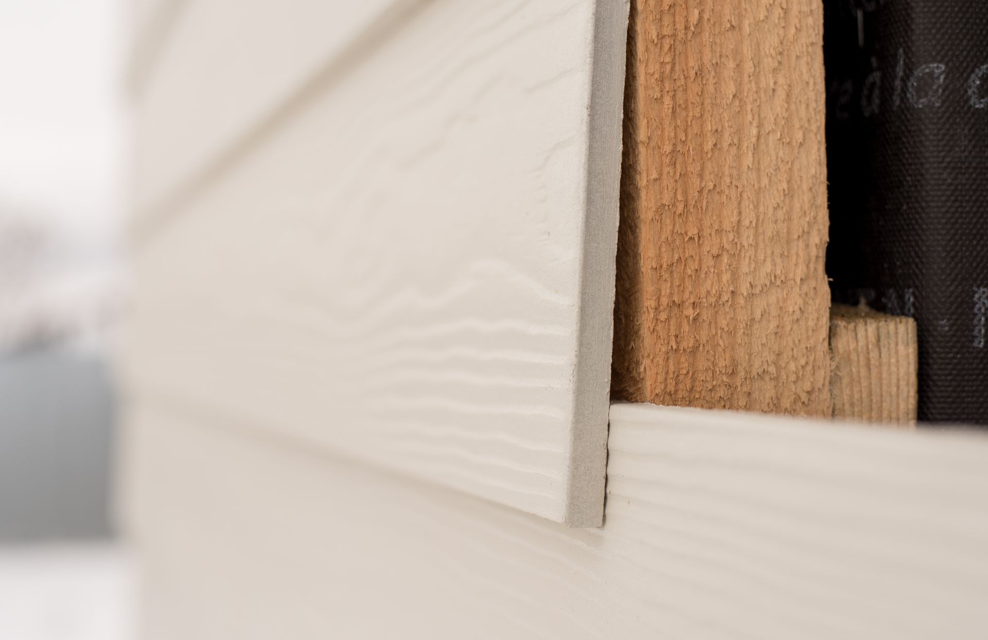 Close-up of white and wood cabinet panels with a narrow gap showing the interior.