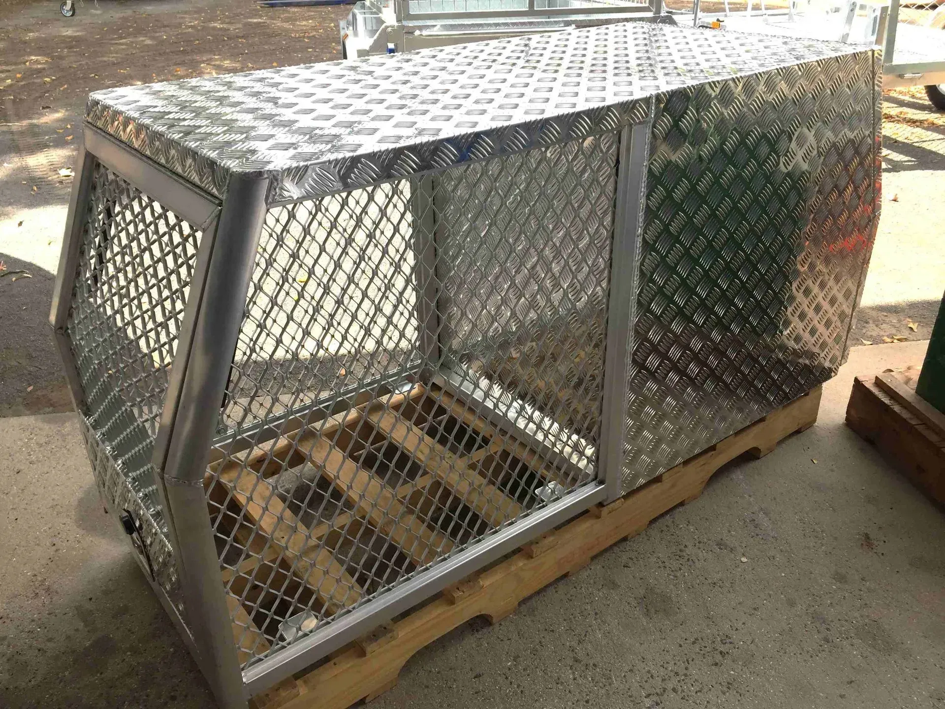 Metal Mesh Animal Crate on A Pallet in An Outdoor Industrial Setting — SSCFW Trailers In Mareeba, QLD