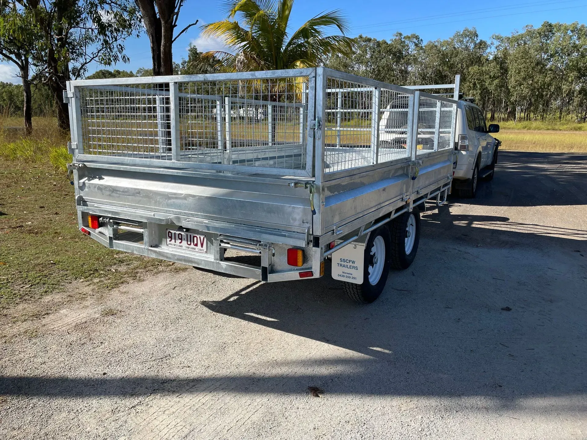 Silver Flatbed Utility Trailer Parked on A Dirt Roadside Near Trees — SSCFW Trailers In Innisfail, QLD