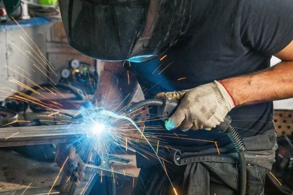 Welder in Gloves and Helmet Sparks Metal in A Workshop — SSCFW Trailers In Mareeba, QLD