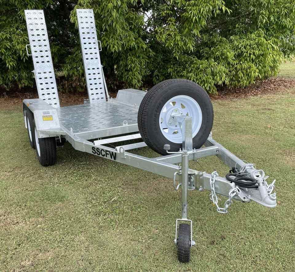 Silver Boat Trailer on Grass with A Spare Wheel and Two Upright Ramps — SSCFW Trailers In Mareeba, QLD