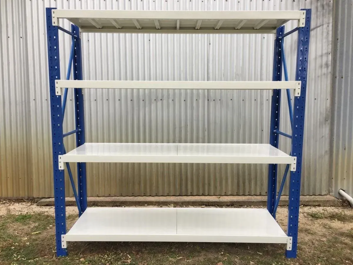 Blue metal shelving unit with four white shelves against a corrugated metal wall in a shed. — SSCFW Trailers In Mareeba, QLD