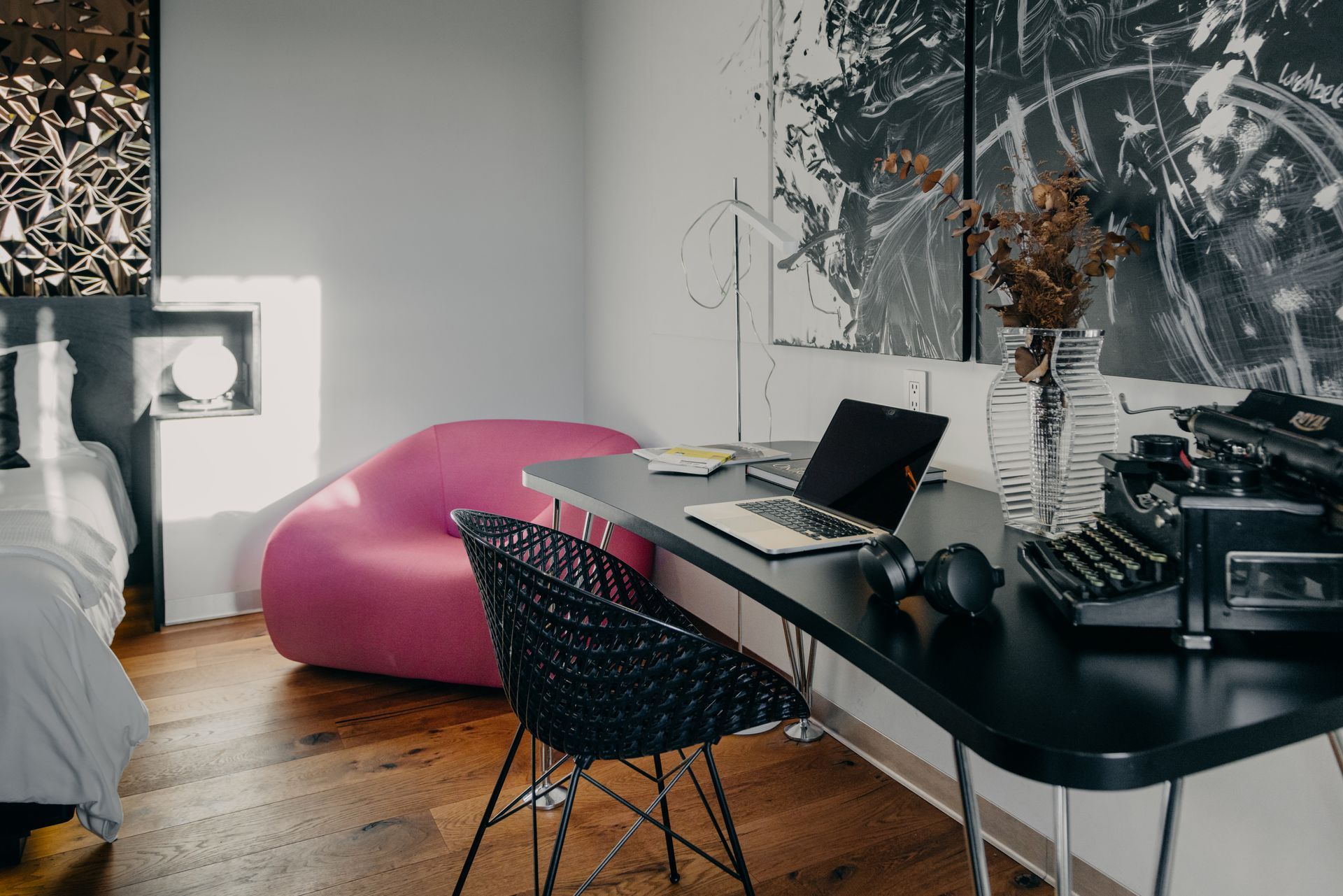 Una habitación con un escritorio, una silla, una computadora portátil y una máquina de escribir.