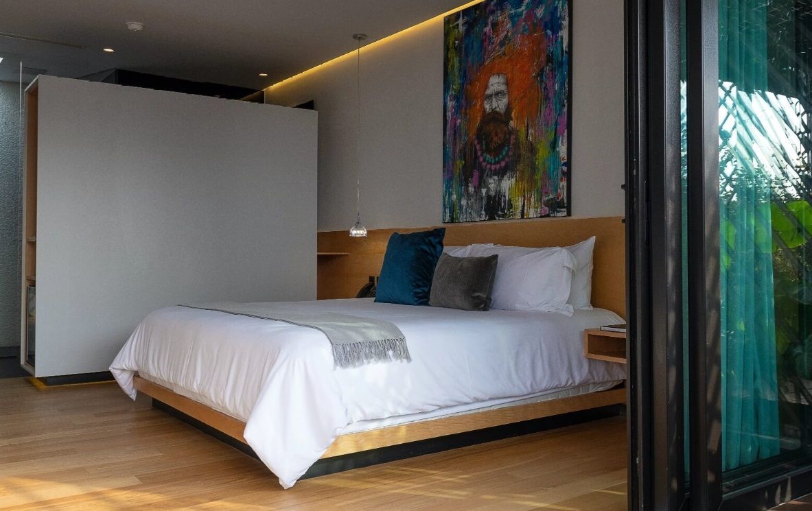 Un dormitorio con una cama grande y un cuadro en la pared.