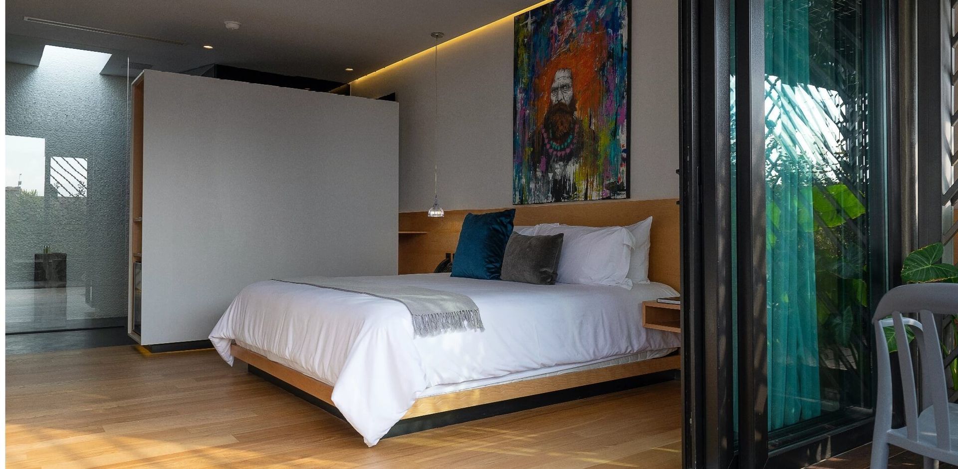 Un dormitorio con una cama grande y un cuadro en la pared.