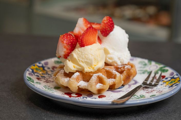 Pasticcini e caffè su un tavolo con arredamento da bar all'aperto.