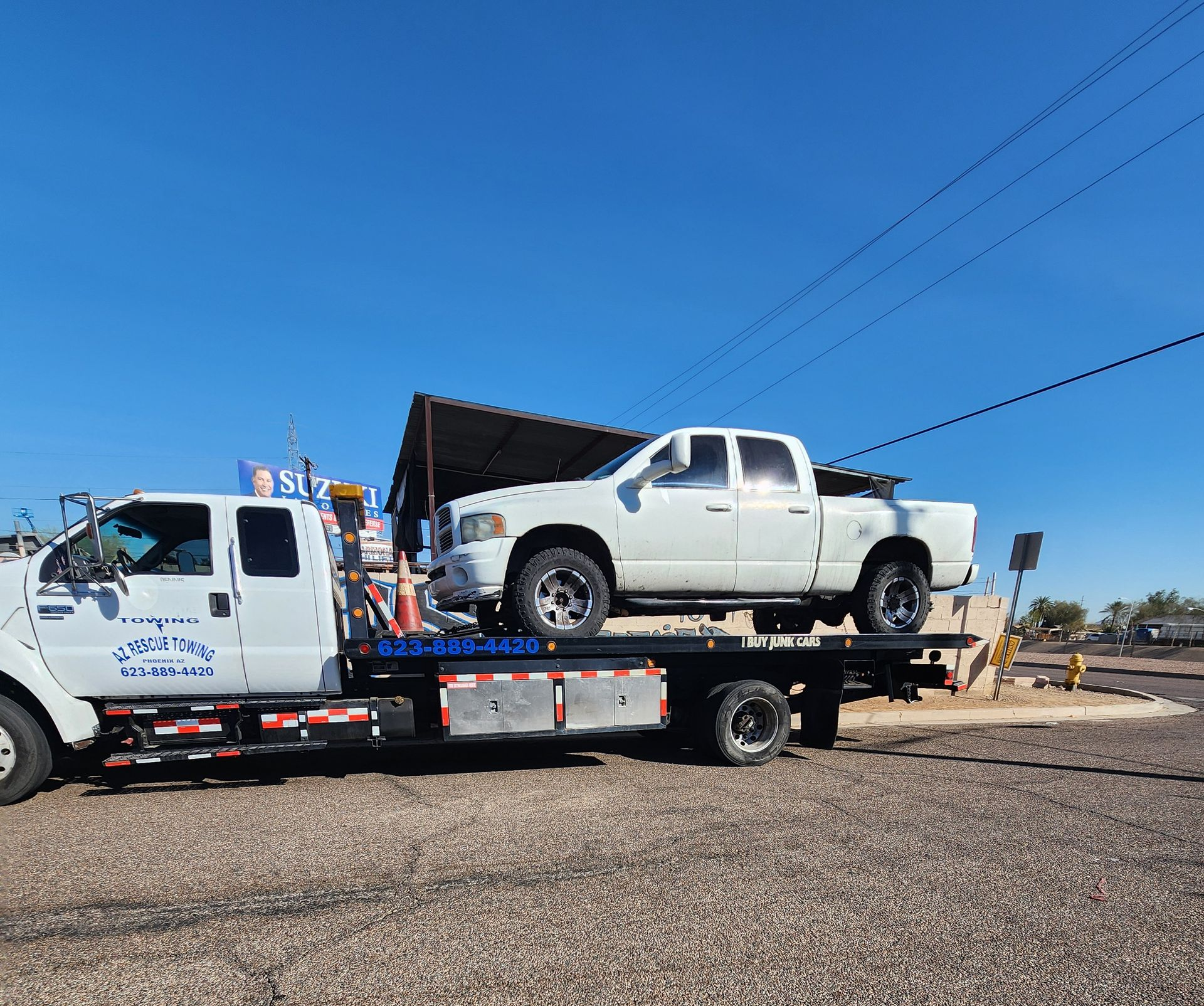 Red hot rod being towed on a flatbed tow truck. The truck is white.
