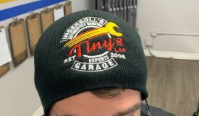 A man wearing a black beanie with a wrench on it. | Tiny's Automotive
