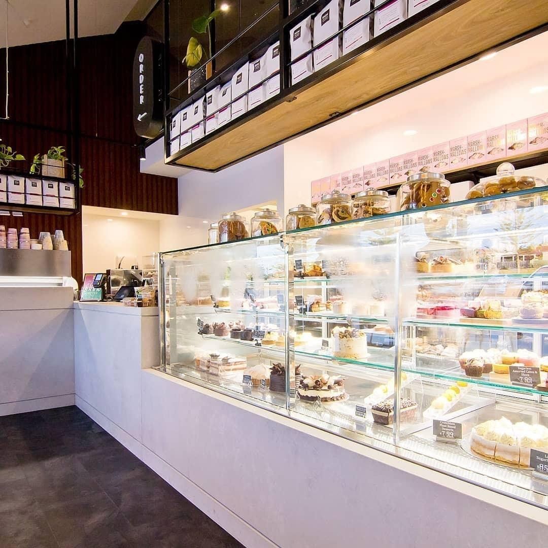 Cake and dessert display cabinet with pastries, cakes and sweet treats showcased inside a modern café and bakery.