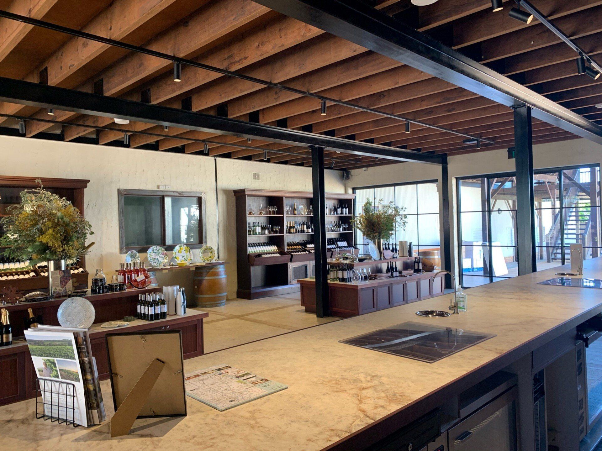 Winery cellar door tasting room with wine displays, timber shelving, tasting counter and large open-plan interior.