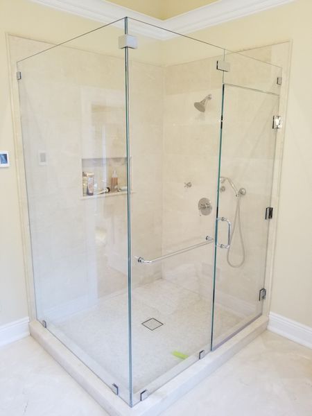 A bathroom with a glass shower stall and a shower head.