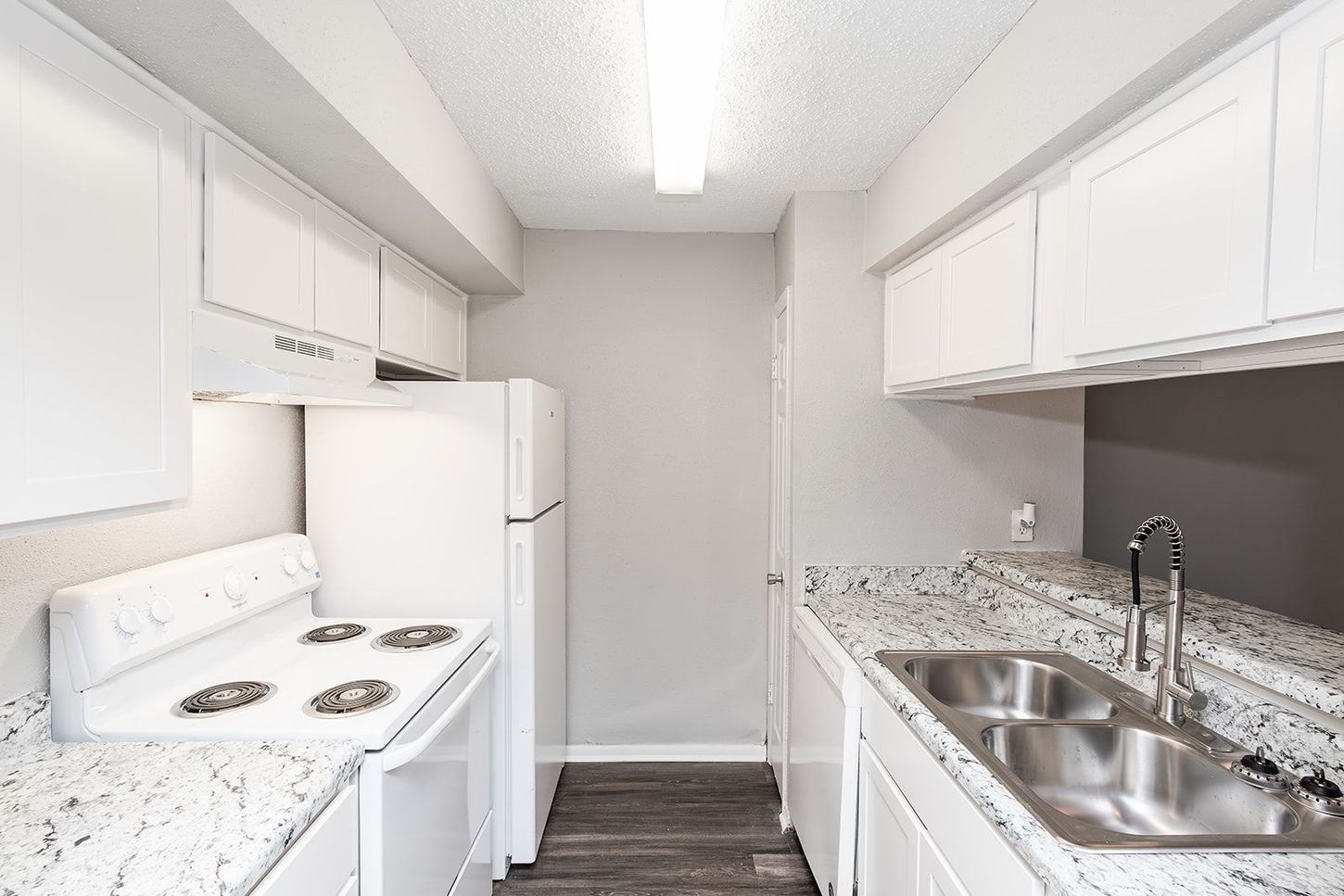 A kitchen with two sinks , a stove , a refrigerator , and a microwave.