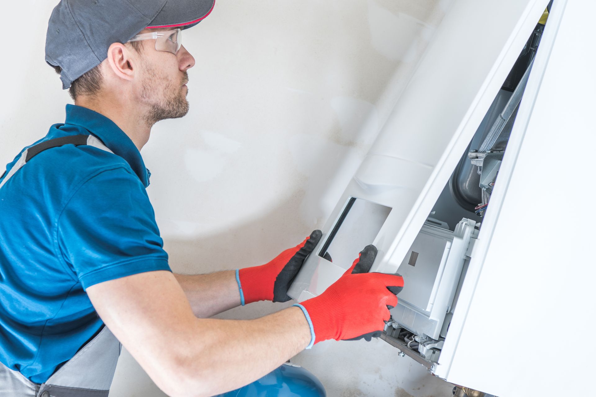 A man is working on a furnace. 