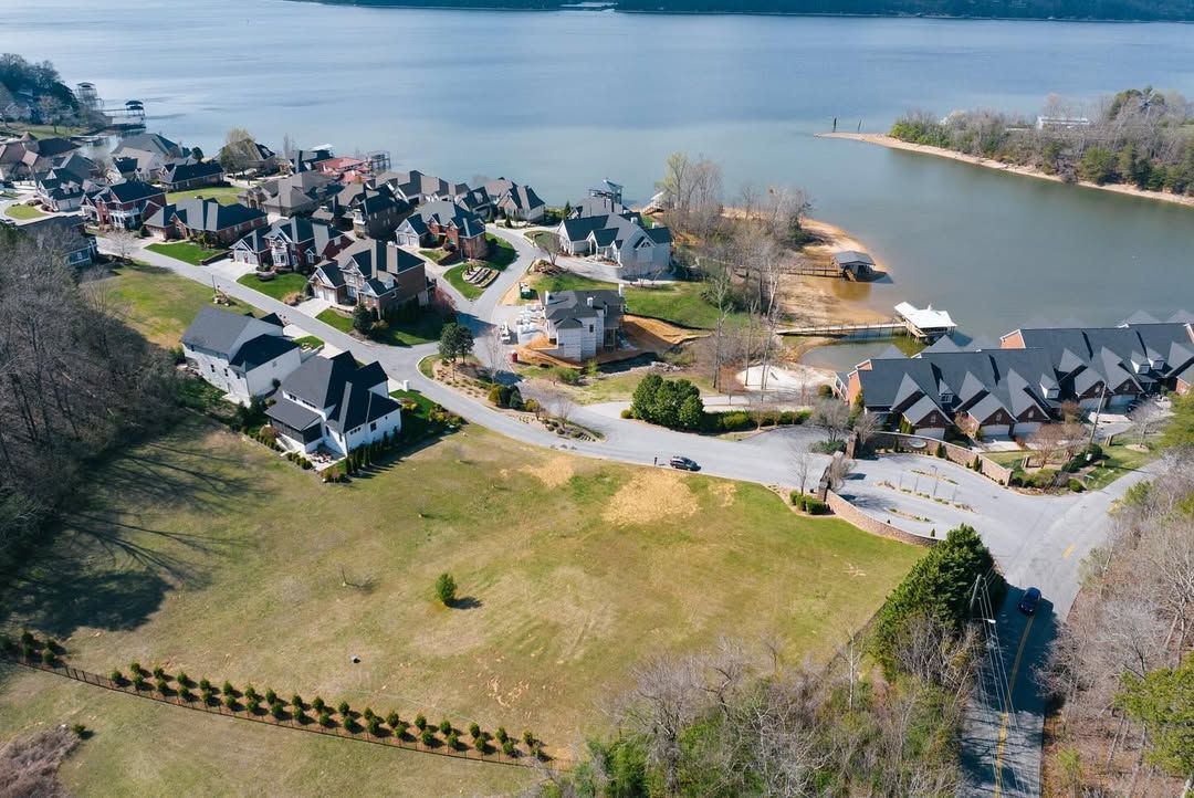 Aerial view of lakeside homes and a body of water on a sunny day.