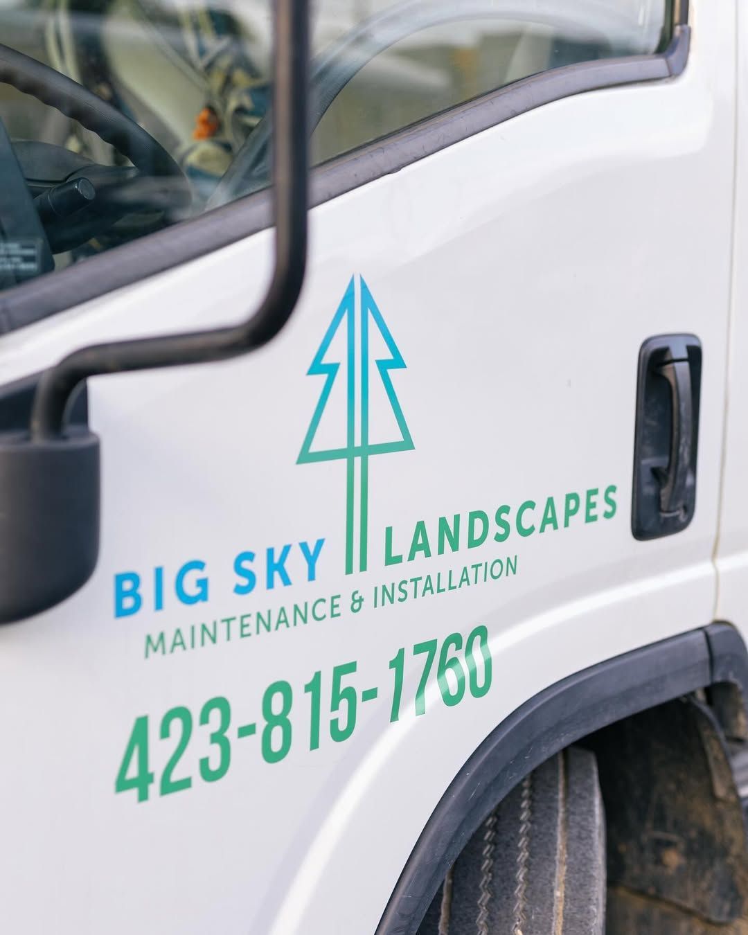 White truck with Big Sky Landscapes logo and phone number.
