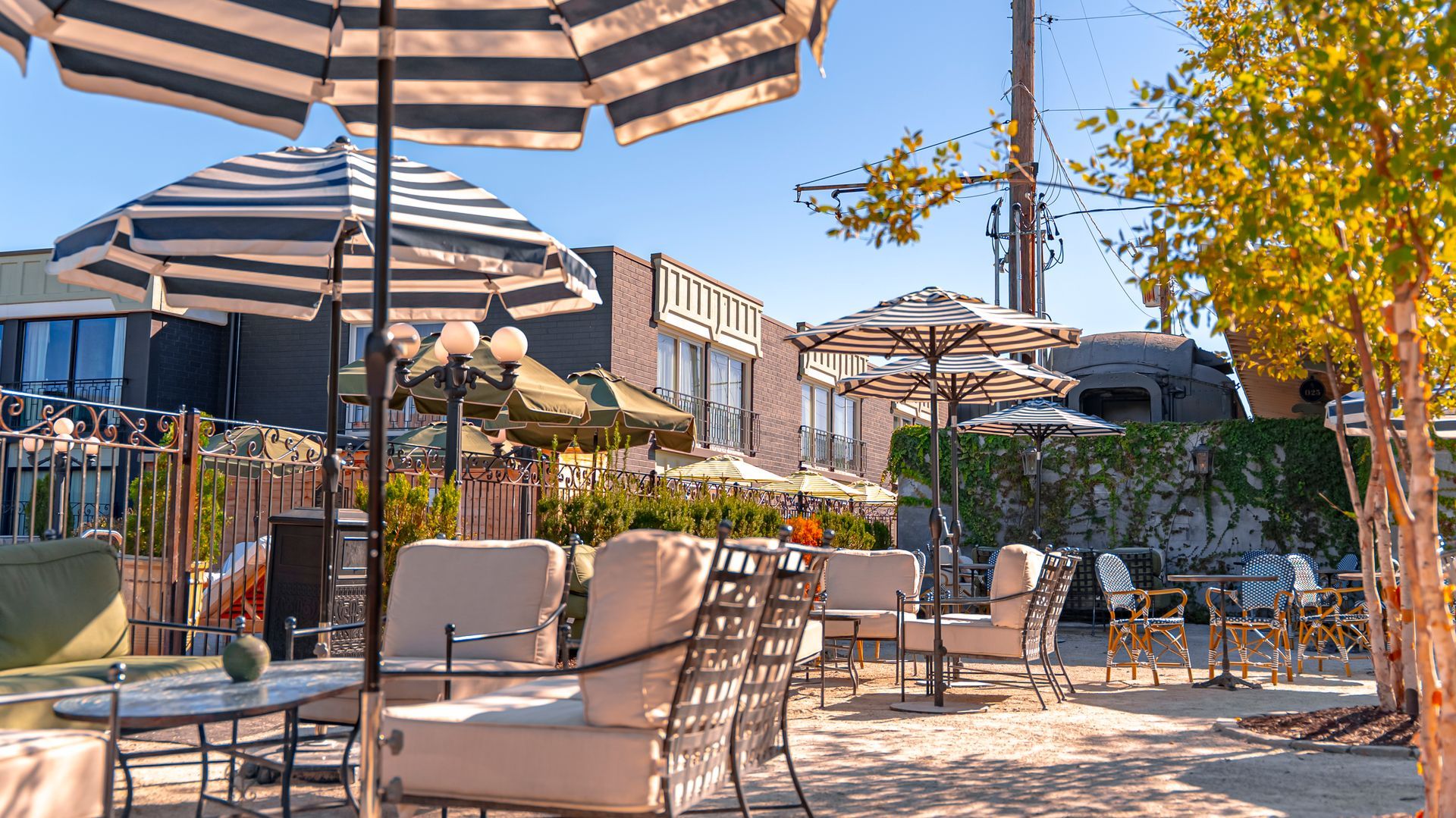 Outdoor restaurant patio with striped umbrellas and seating.
