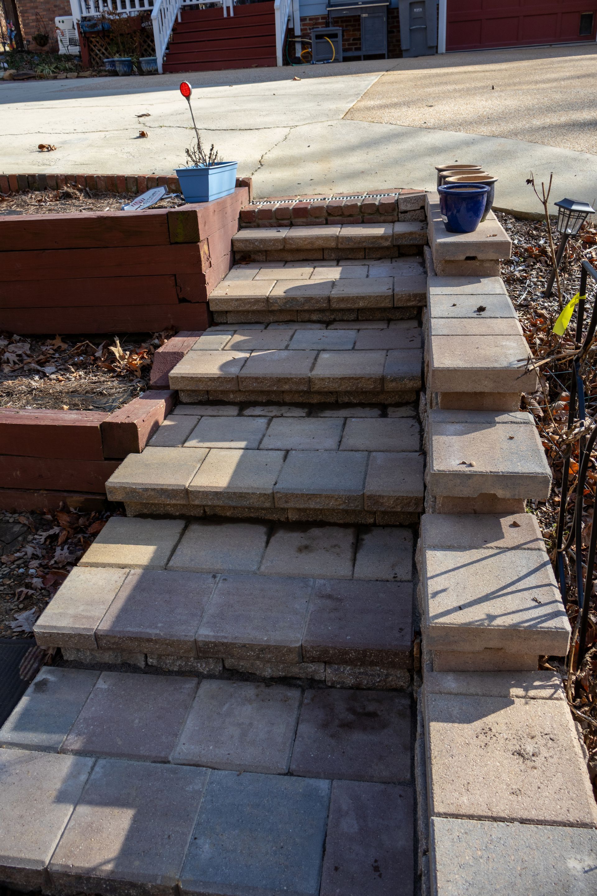 Brick steps leading up, bordered by brick and a raised flower bed.