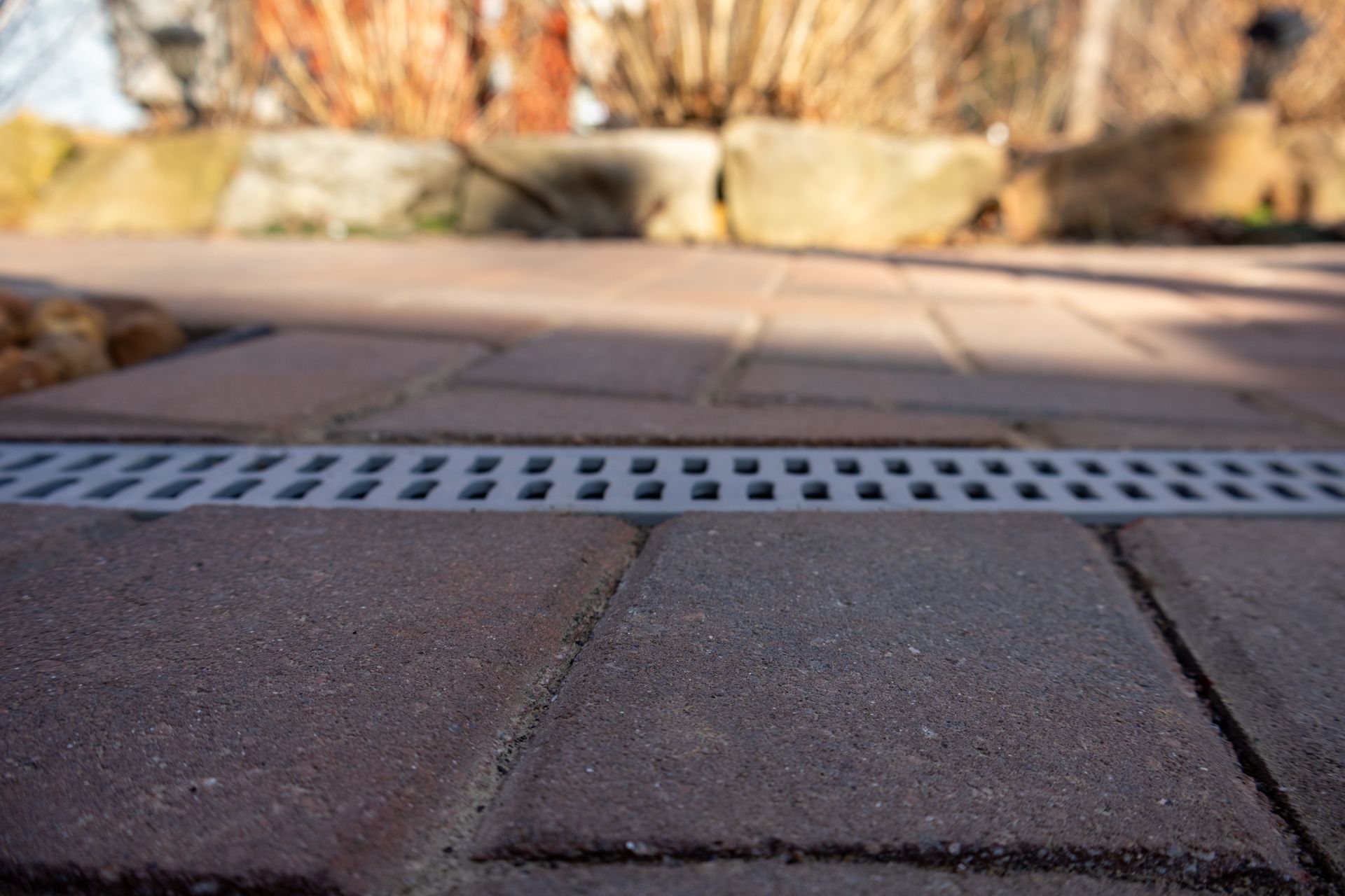 Brick patio with a linear drainage grate.