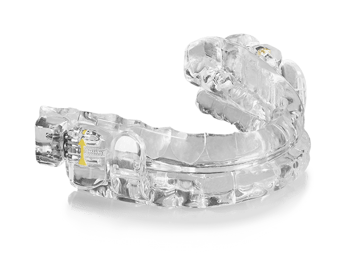 A clear dental device is sitting on a white surface.