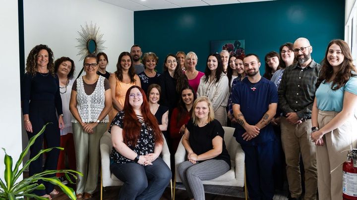 A group of people are posing for a picture in a room.