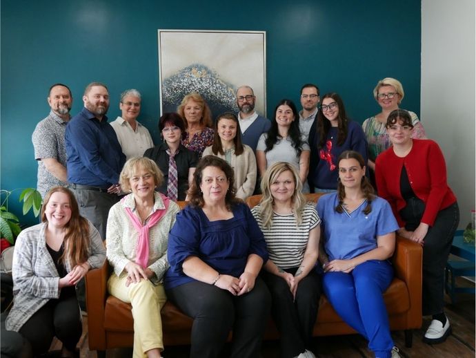 A group of people are posing for a picture in a room.