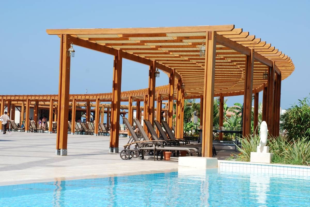 An outdoor commercial pergola, providing coverage to lounge chairs at a stunning hotel pool area near Central Pennsylvania