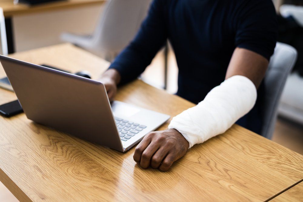 Injured Man Using Laptop — Gibsonville, NC — Walker & Bullard PA Injured Man Using Laptop — Gibsonville, NC — Walker & Bullard PA